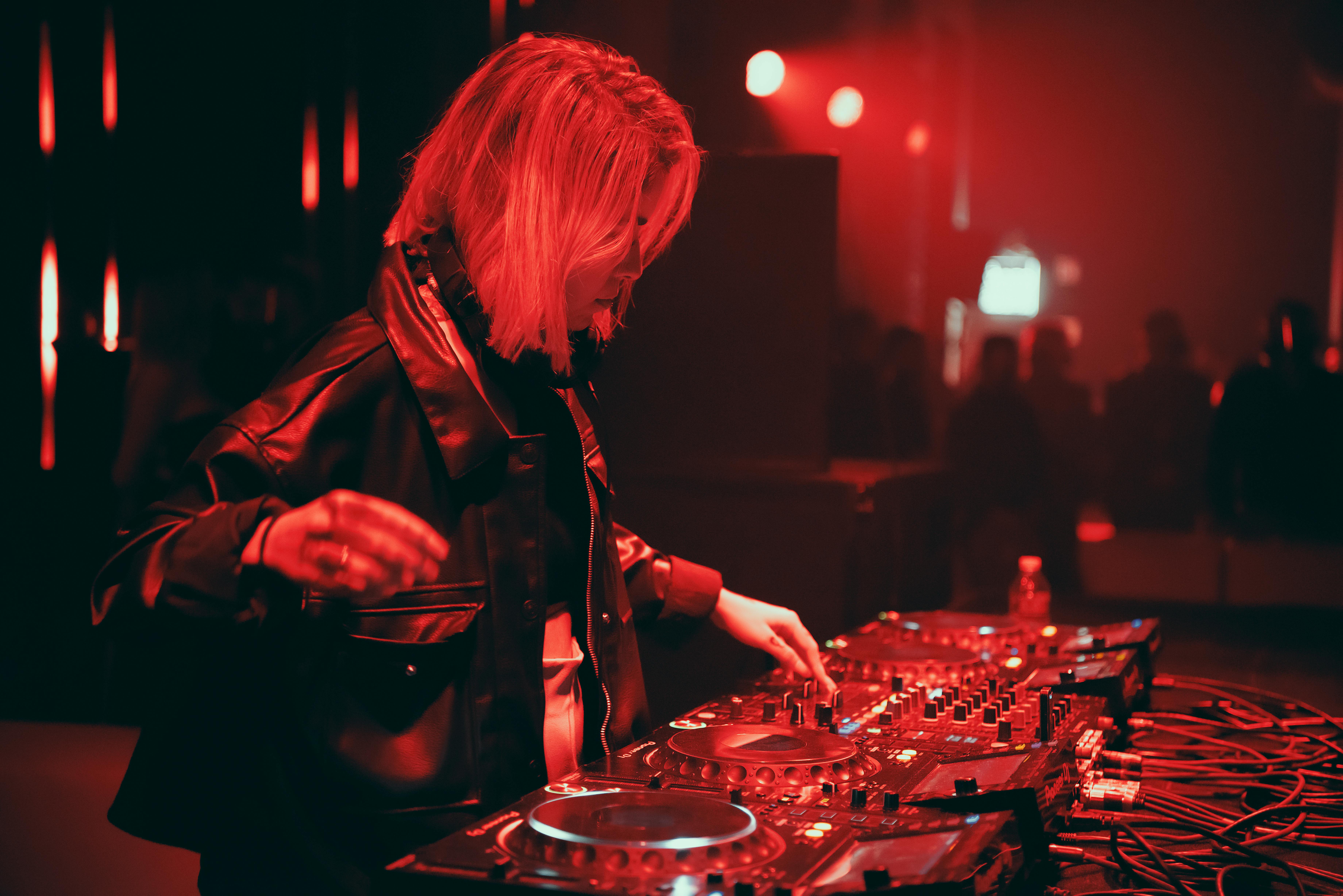 A rave in an industrial warehouse with a balcony